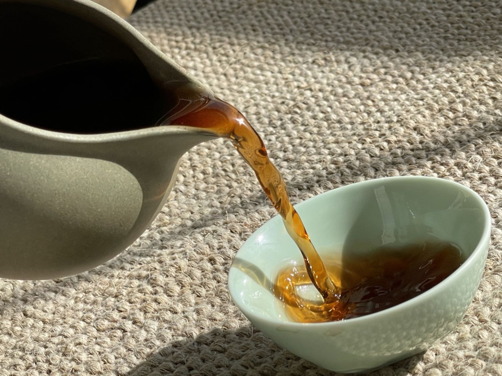 Pu'er tea is poured into a light green tea cup.